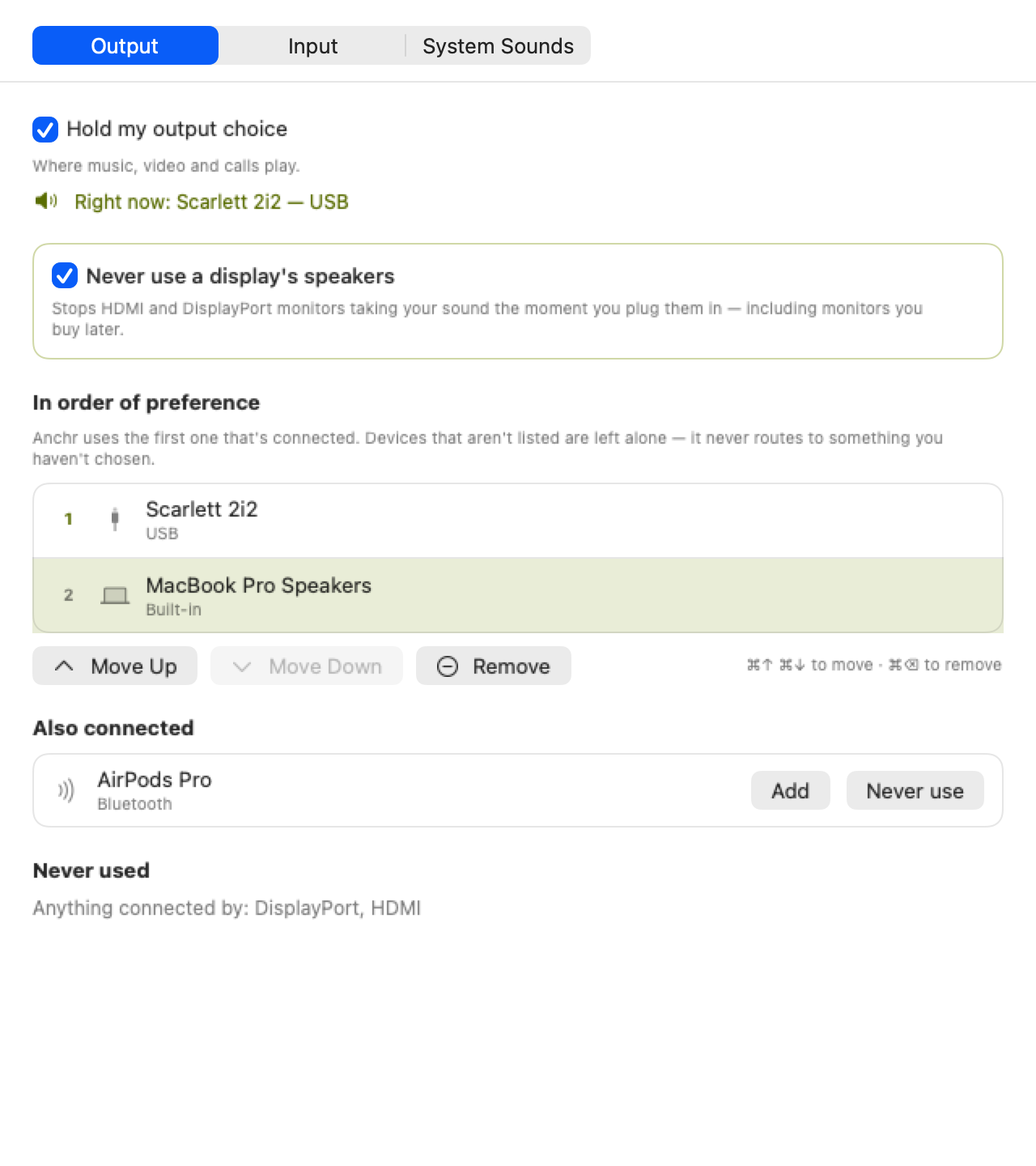 Anchr's Devices settings — a segmented Output, Input and System Sounds picker, a switch reading Never use a display's speakers, and a numbered list of preferred devices with Scarlett 2i2 first and MacBook Pro Speakers second, with Move Up, Move Down and Remove buttons beneath